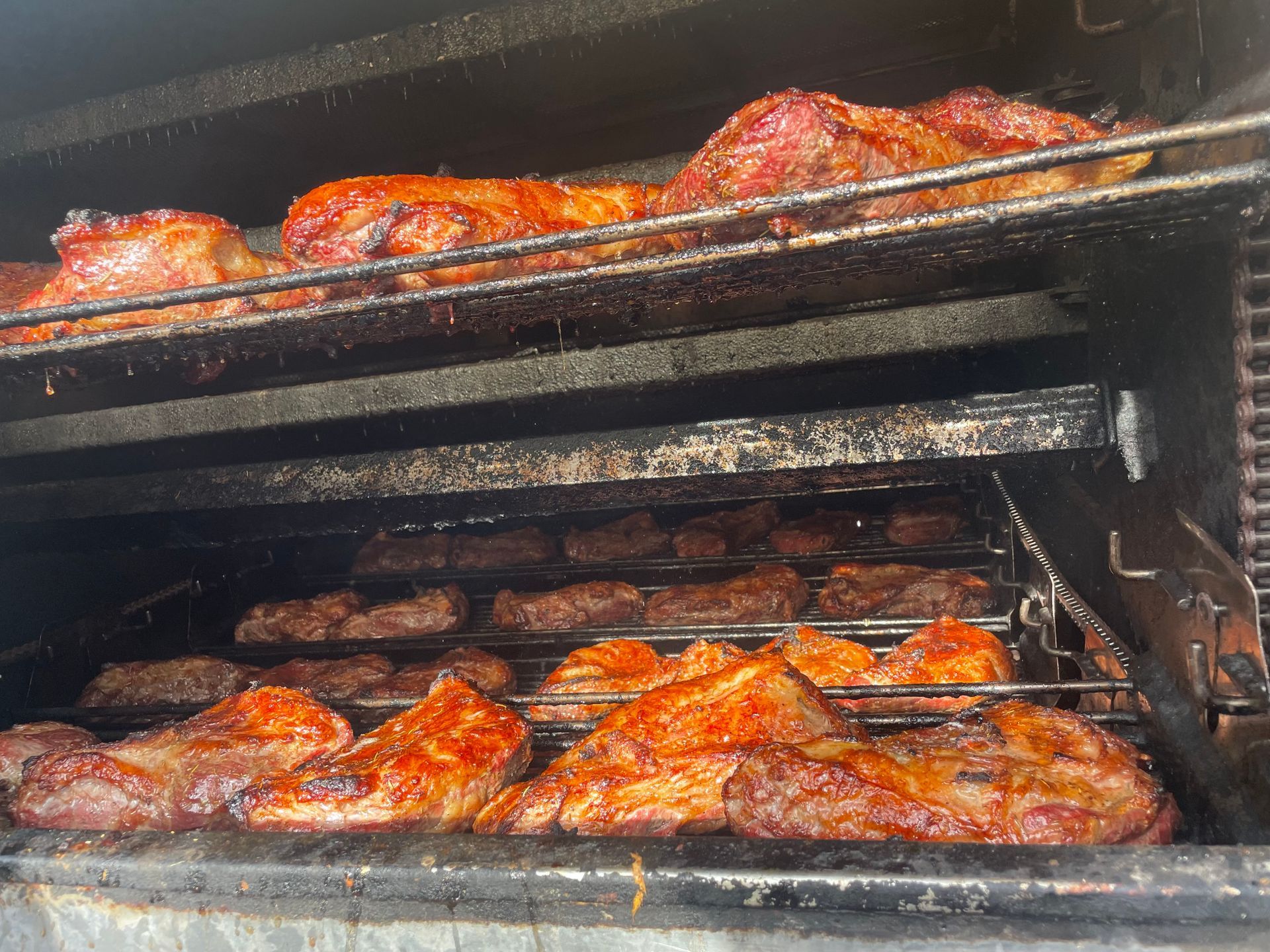 Smoked meats cooking inside the pit